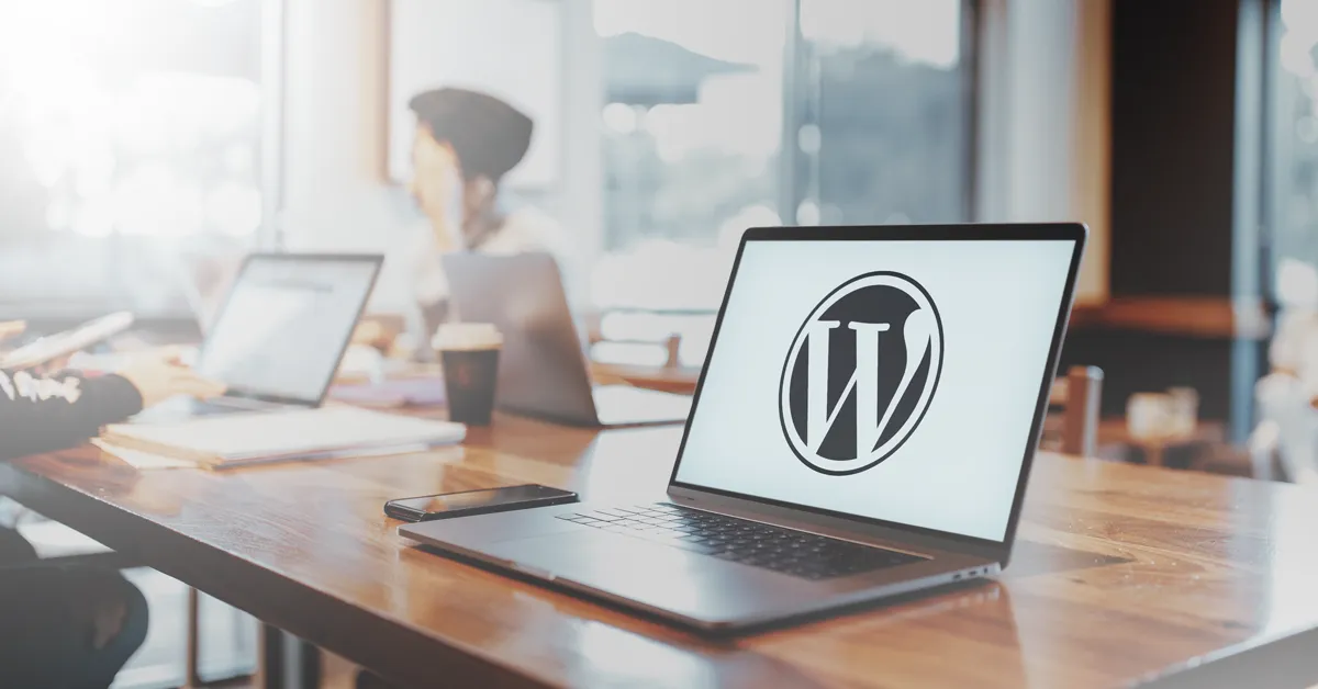 Computer in cafe setting with W WordPress logo